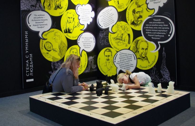 дети играют в шахматы скульпторами животных в Музее природы Новосибирска